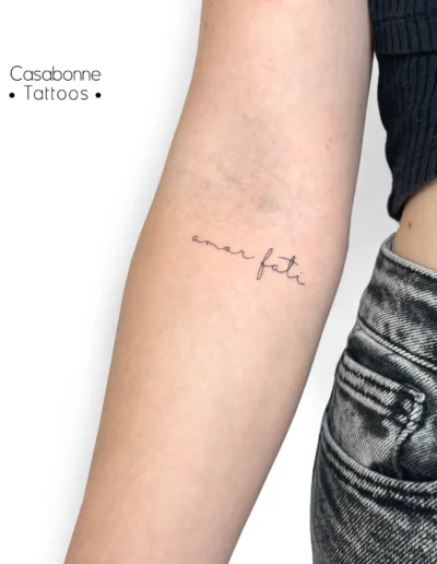 Tatouage de la locution latine 'amor fati', sur le bras, à Toulouse