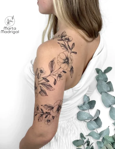 Tatouage floral d'anemones et de boutons d'or en guirlande sur l'epaule et le bras, a Toulouse