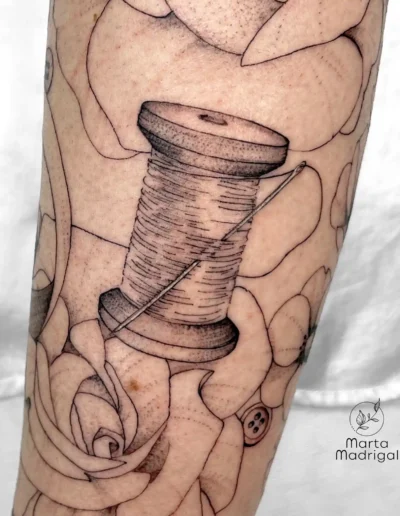 Tatouage d'une bobine de fil (thème couture), sur le bras, à Toulouse