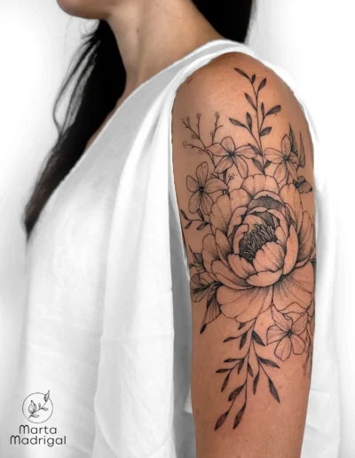 Tatouage d'un bouquet de pivoine et de jasmin en noir et gris sur le haut du bras, a Toulouse