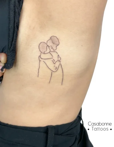 Tatouage ligne fine d'un câlin avec la grand-mère, sur les côtes, à Toulouse