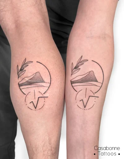 Tatouage assorti d'un cercle avec une montagne et une branche, sur la jambe, à Toulouse (tatouage en duo)