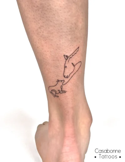Tatouage ligne fine d'un cheval et d'un chien, sur la jambe, à Toulouse