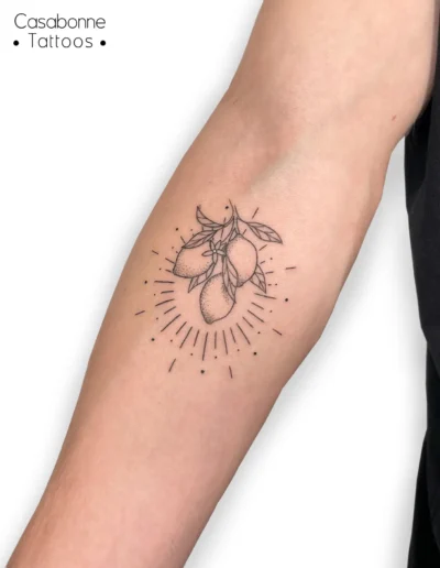 Tatouage dotwork de citrons avec un soleil rayonnant, sur l'avant-bras, à Toulouse