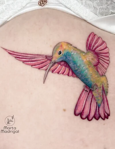 Tatouage couleur d'un colibri en vol, sur le haut du dos, à Toulouse