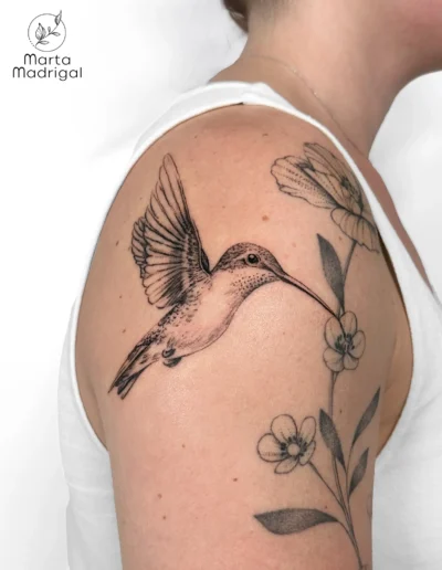 Tatouage d'un colibri butinant une fleur, sur le bras, à Toulouse