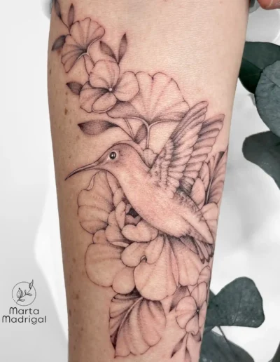 Tatouage d'un colibri parmi des fleurs, sur l'avant-bras, à Toulouse