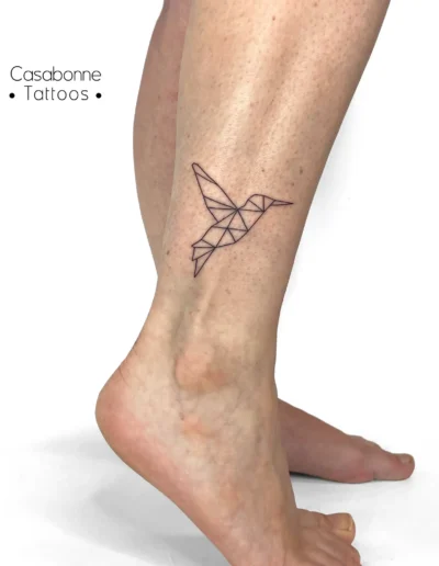 Tatouage d'un colibri géométrique origami, sur la cheville, à Toulouse