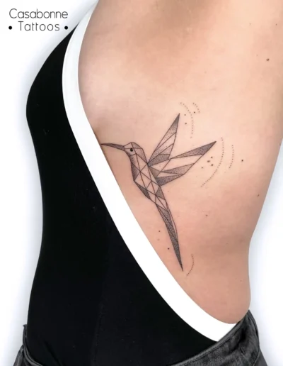 Tatouage d'un colibri géométrique origami, sur les côtes, à Toulouse