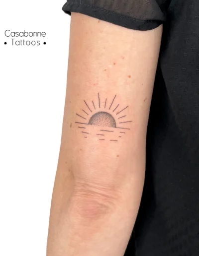 Tatouage dotwork d'un coucher de soleil, sur le bras, à Toulouse