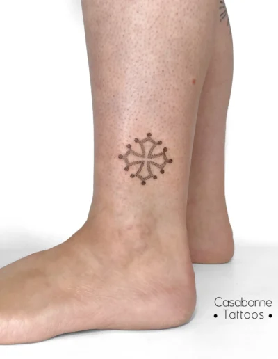 Tatouage d'une croix occitane, sur la cheville, à Toulouse