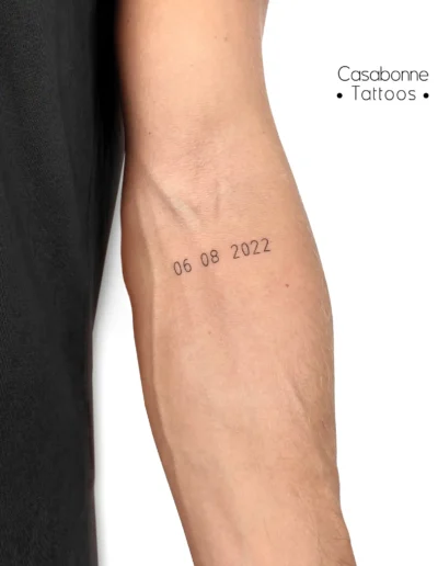 Tatouage d'une date de naissance, sur le bras, à Toulouse