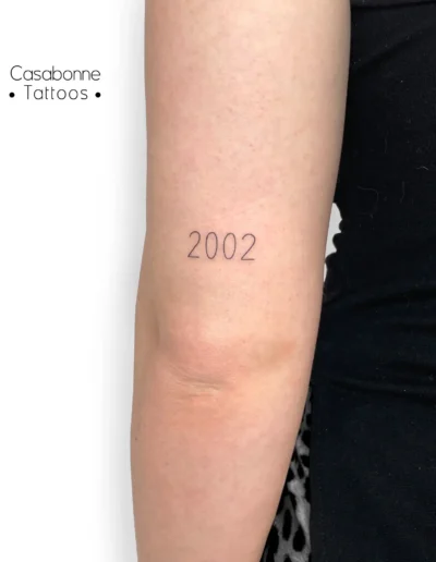Tatouage d'une date, sur le bras, à Toulouse