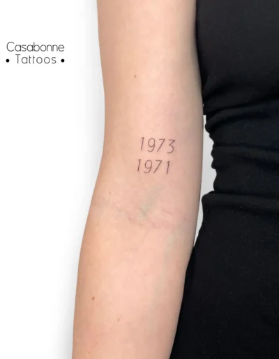 Tatouage de deux dates, sur le bras, à Toulouse