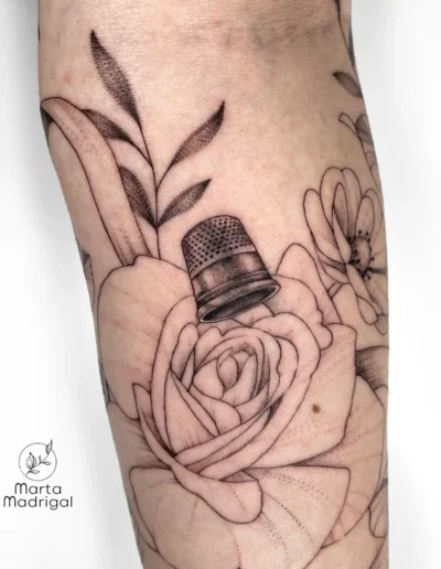 Tatouage d'un dé à coudre et d'une rose (thème couture), sur le bras, à Toulouse