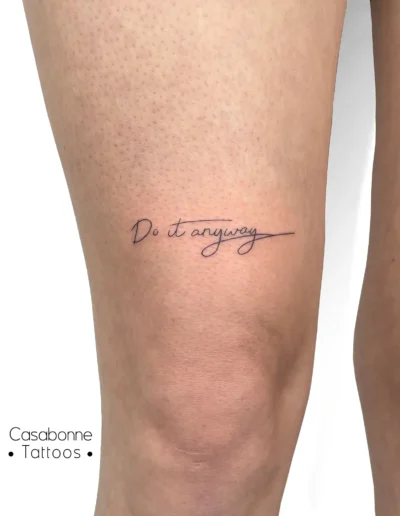 Tatouage de l'inscription 'Do it anyway', sur la jambe, à Toulouse