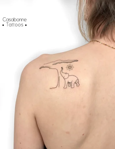 Tatouage ligne fine d'un éléphant sous un arbre avec un soleil, sur le dos, à Toulouse