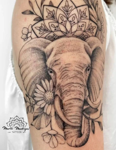 Tatouage d'une tête d'éléphant avec une guirlande florale façon mandala, sur le bras, à Toulouse