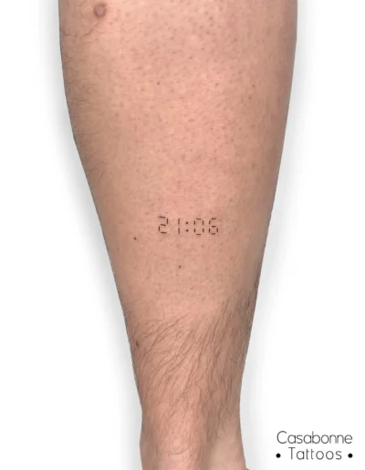 Tatouage d'une heure au format digital, sur la jambe, à Toulouse