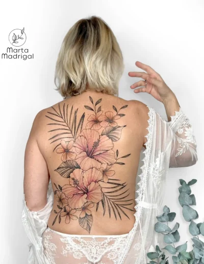 Tatouage tropical d'hibiscus et frangipanier sur tout le dos, a Toulouse
