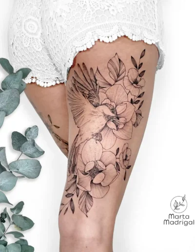 Tatouage d'une hirondelle parmi des fleurs, à l'arrière de la cuisse, à Toulouse