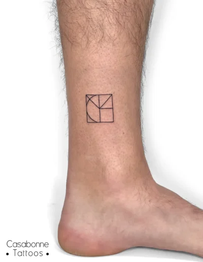 Tatouage d'initiales stylisées sous forme géométrique, sur la cheville, à Toulouse