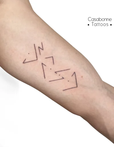 Tatouage de lettres stylisées représentant la fratrie, sur le bras, à Toulouse