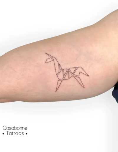 Tatouage d'une licorne géométrique origami, sur le bras, à Toulouse