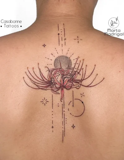 Tatouage de lys-araignee avec motifs astraux, haut du dos, a Toulouse