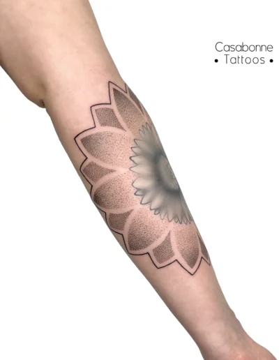 Tatouage dotwork d'un mandala fleuri, sur la jambe, à Toulouse