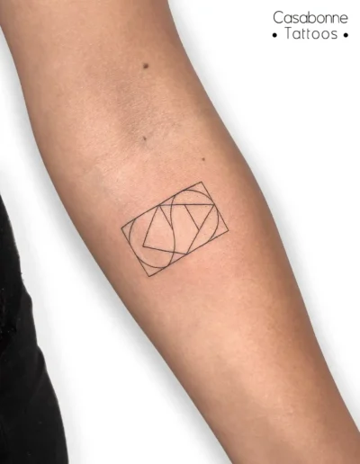 Tatouage d'un monogramme géométrique, sur l'avant-bras, à Toulouse