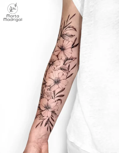 Tatouage d'un personnage Moonies et de fleurs d'eglantier sur l'avant-bras, a Toulouse