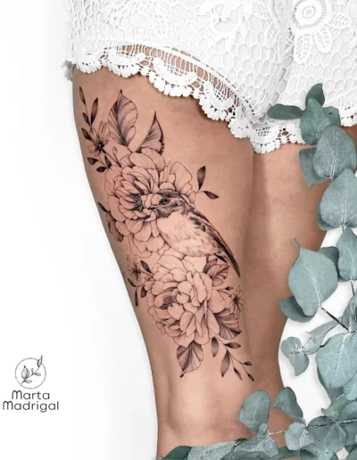 Tatouage d'un oiseau parmi des fleurs, sur la cuisse, à Toulouse