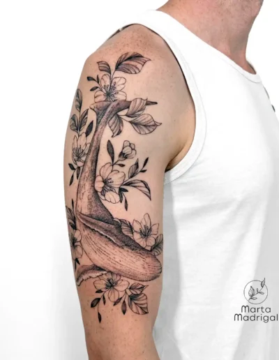 Tatouage d'un oiseau parmi des fleurs, sur le haut du bras, à Toulouse