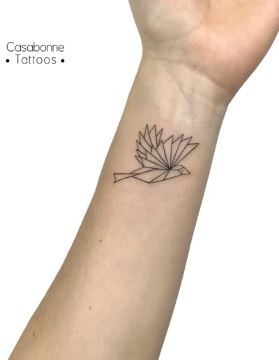 Tatouage ligne fine d'un oiseau géométrique origami, sur l'avant-bras, à Toulouse