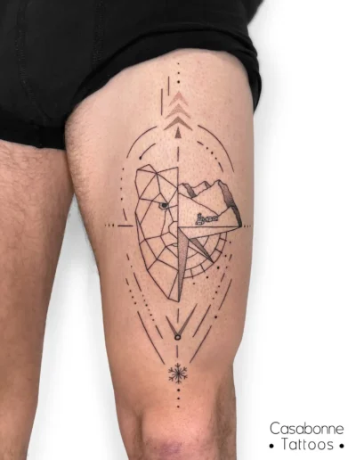 Tatouage géométrique d'un ours et de montagnes dans une boussole, sur la cuisse, à Toulouse