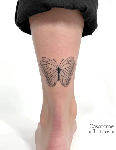 Tatouage dotwork d'un papillon en plein envol, sur la cheville, à Toulouse