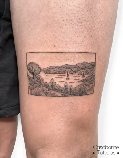 Tatouage dotwork d'un paysage encadré (lac et montagnes), sur le bras, à Toulouse