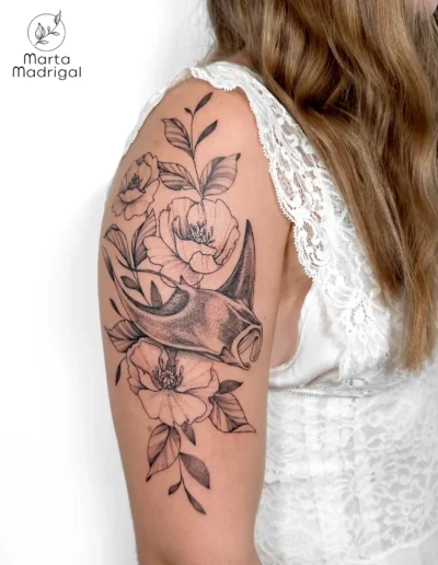 Tatouage d'une raie manta parmi des fleurs, sur le haut du bras, à Toulouse