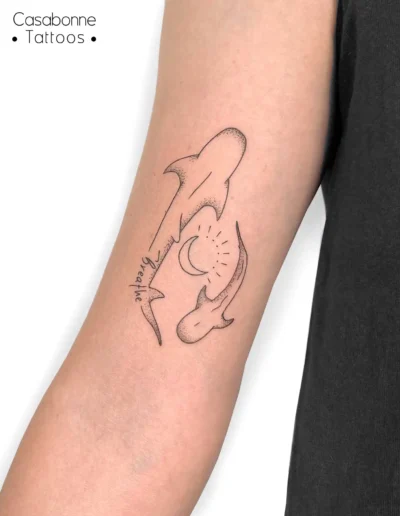 Tatouage ligne fine d'un requin, d'une baleine et d'une lune, sur l'avant-bras, à Toulouse