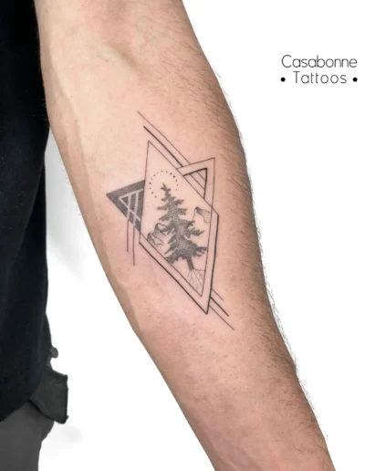Tatouage dotwork de sapins dans des triangles géométriques, sur l'avant-bras, à Toulouse