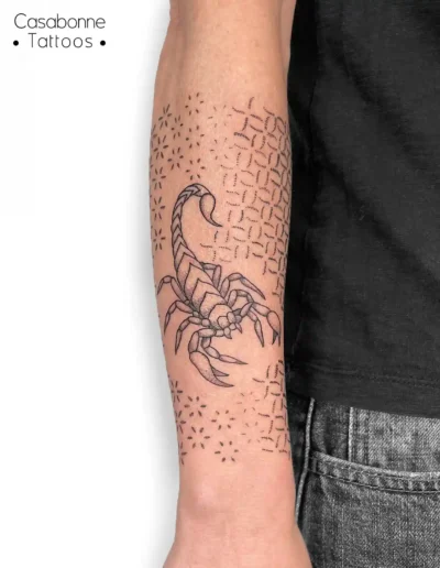 Tatouage d'un scorpion avec des patrons géométriques dotwork, sur l'avant-bras, à Toulouse