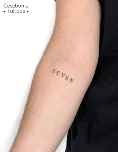 Tatouage du mot 'Seven', sur le bras, à Toulouse