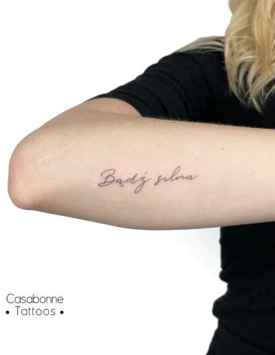 Tatouage de l'inscription 'Bądź silna' (sois forte, en polonais), sur le bras, à Toulouse
