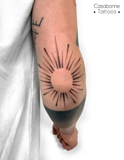 Tatouage dotwork d'un soleil, sur le coude, à Toulouse