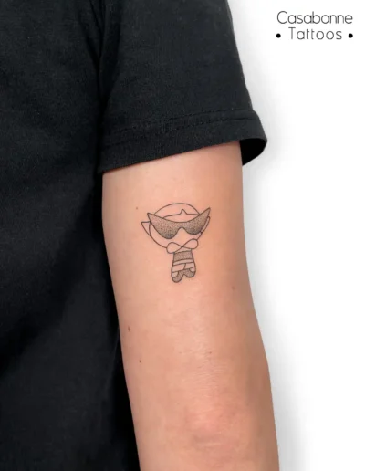Tatouage d'un personnage inspiré des Supers Nanas, sur le bras, à Toulouse