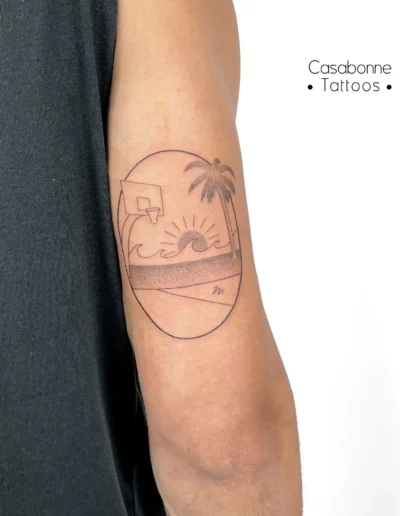 Tatouage ligne fine d'un terrain de basket et coucher de soleil style Miami, sur le bras, à Toulouse