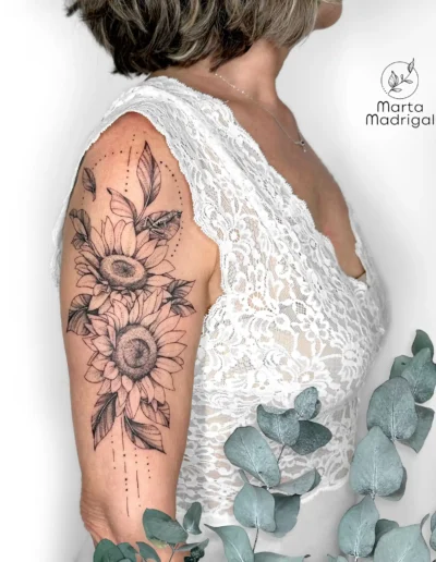 Tatouage de tournesols avec petite grenouille cachee, haut du bras, a Toulouse