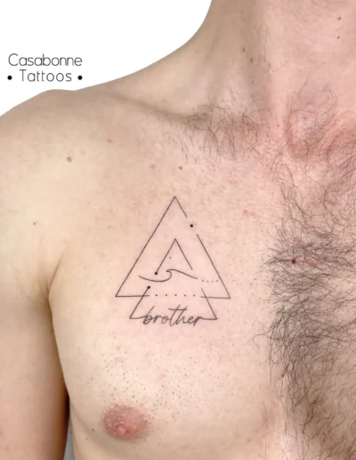 Tatouage d'un triangle géométrique avec une vague et l'inscription 'brother', sur la poitrine, à Toulouse