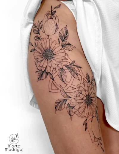 Tatouage d'une triquetra entourée de motifs floraux, sur la hanche, à Toulouse